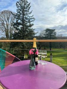 a bottle of champagne and two glasses on a purple table at Chambre dans demeure de caractère in Missy-sur-Aisne