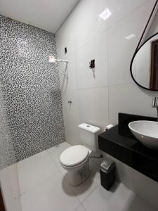 a bathroom with a toilet and a sink and a shower at Casa em Dunas de Marapé -Jequia da praia in Jequia da Praia