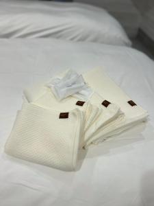 a white robe sitting on top of a bed at Private Stay HANARE in Shishikui