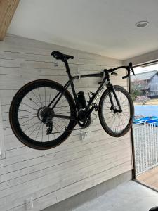 a bike hanging on the wall of a garage at Private Stay HANARE in Shishikui