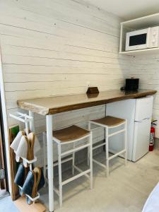 a kitchen with a counter with a table and stools at Private Stay HANARE in Shishikui