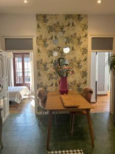 a room with a table with a vase with flowers on it at Casa Balcones in Sahagún
