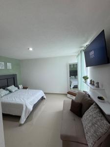 a bedroom with a bed and a couch at Casa Altavista in Pachuca de Soto