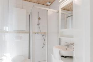 a white bathroom with a shower and a sink at Büdlfarm - Der Familien-Erlebnishof in Strandnähe in Fehmarn +36 photos