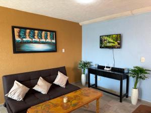 a living room with a couch and a piano at Marina Diamante Plata D5 in Acapulco