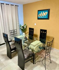 a dining room with a glass table and chairs at Marina Diamante Plata D5 in Acapulco