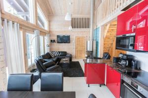 a kitchen with red cabinets and a living room at Villa Stella in Äkäslompolo