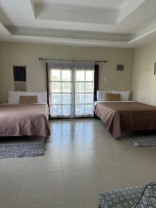 a room with two beds and a large window at Villa Azure in Tower Isle