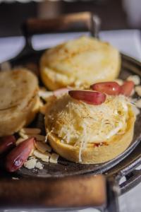 a muffin with cheese and tomatoes on a pan at Altaroma - Pousada e Experiência Gastronômica in Campos do Jordão
