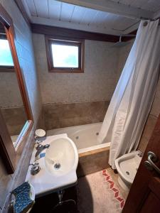 a bathroom with a sink and a bath tub at Aromas de Montaña III in Junín de los Andes +15 photos