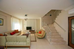 a living room with two couches and a staircase at Paradise Town Villa Alison in Belek