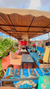 a group of chairs and tables under an umbrella at Hostel kif kif annex in Marrakesh