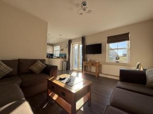 a living room with a couch and a coffee table at 12 Green Close at The Bay Filey, sleeps 8, 2 dogs welcome for free too in Filey