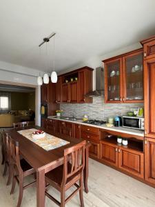 a kitchen with wooden cabinets and a wooden table at Aidone Sunset House in Aidone