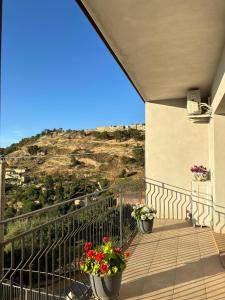 a balcony with two pots of flowers on a building at Aidone Sunset House in Aidone