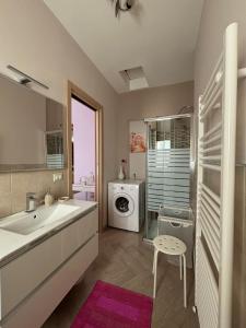 a bathroom with a sink and a washing machine at Aidone Sunset House in Aidone