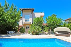 a villa with a swimming pool in front of a house at Paradise Town Villa Beldora in Belek