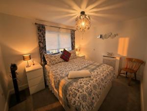 a bedroom with a bed and a window and a chandelier at Dreghorn House 5 b-rooms 9 beds 3 toilets 2 showers,1 bath 2 receiption Secure free Parking 233 Wifi in Edinburgh