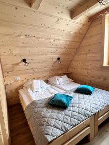 a bedroom with two beds in a log cabin at Żabie Dworki Witów Luxury Chalets & SPA in Witów +132 photos