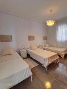 a room with three beds and a chandelier at Entre Mar y Montañas in Vall de Uxó