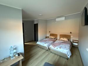 a bedroom with two beds and a table and a mirror at Duplex Oasis Rooms in Ada
