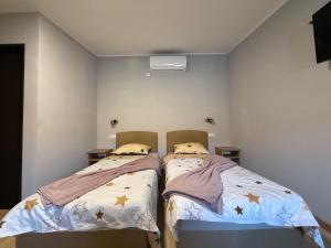 two beds in a small room with two bedsskirts at Duplex Oasis Rooms in Ada