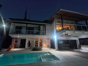 a villa with a swimming pool at night at Casa Caminho do Meio in Rio de Janeiro