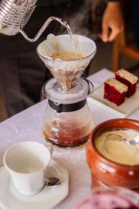 a cup of coffee and a blender on a table at Altaroma - Pousada e Experiência Gastronômica in Campos do Jordão +188 photos