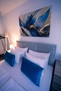 a bedroom with blue pillows and a painting on the wall at Villa Laguna Mostar in Mostar +59 photos