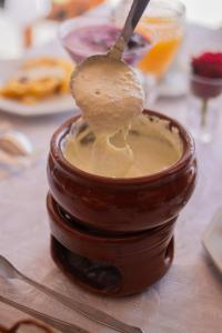a spoon in a jar filled with peanut butter at Altaroma - Pousada e Experiência Gastronômica in Campos do Jordão