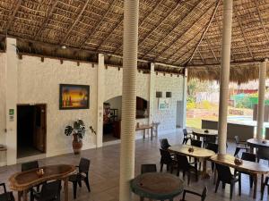 a restaurant with tables and chairs and a ceiling at RodMar Hotel in El Cuco