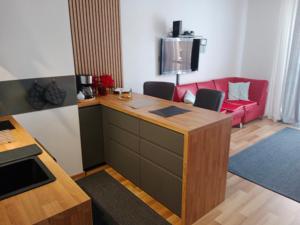 a living room with a desk and a red couch at Apartament - Elbląg in Elblag