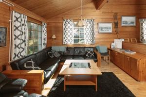 a living room with a black leather couch and a table at Villa Polaris in Äkäslompolo