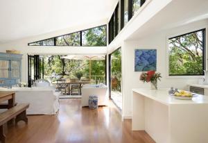 a kitchen and dining room with large windows at Pittwater Hideaway in Palm Beach