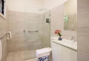 a bathroom with a shower and a toilet and a sink at Pittwater Hideaway in Palm Beach