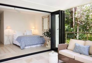 a bedroom with a bed and a sliding glass door at Pittwater Hideaway in Palm Beach