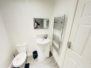 a white bathroom with a toilet and a sink at Doncaster 2 Bedroom Luxury Apartment in Doncaster