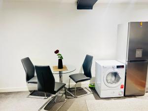 a laundry room with a washer and a table with chairs at Doncaster 2 Bedroom Luxury Apartment in Doncaster