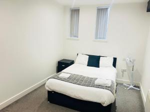 a bedroom with a bed in a white room at Doncaster 2 Bedroom Luxury Apartment in Doncaster