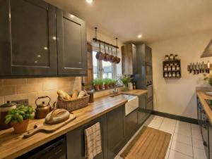 a kitchen with black cabinets and a counter top at Dreghorn House 5 b-rooms 9 beds 3 toilets 2 showers,1 bath 2 receiption Secure free Parking 233 Wifi in Edinburgh