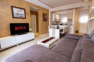a living room with a couch and a tv and a kitchen at Hotel Butua Residence in Budva