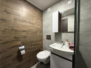 a bathroom with a white toilet and a sink at Duplex Oasis Rooms in Ada