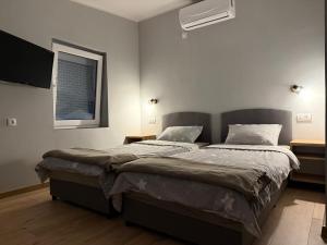 a bedroom with two beds and a window at Duplex Oasis Rooms in Ada +18 photos