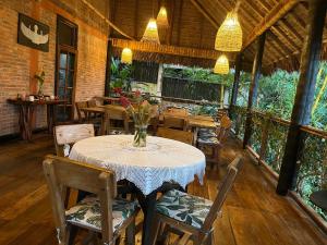 a dining room with a table and chairs and lights at Casa de Campo in Rurrenabaque