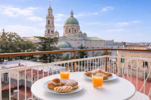 two plates of pastries on a table on a balcony with orange juice at Aurum Pompei Suites in Pompei