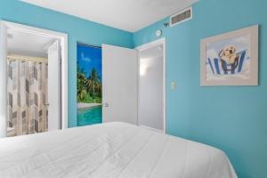 a bedroom with a white bed and blue walls at Oceanfront 1BR Condo with Corner Balcony Pool in Myrtle Beach +45 photos