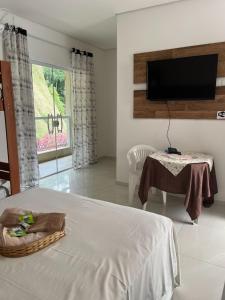 a bedroom with a bed and a television on a wall at Pousada Moriah 700 metrôs Magic City in Suzano