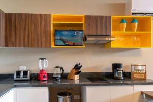 a kitchen with yellow cabinets and a counter top at Beachside Studio & Jacuzzi Bliss in Playa del Carmen