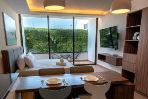 a room with a bed and a large window at Beachside Studio & Jacuzzi Bliss in Playa del Carmen