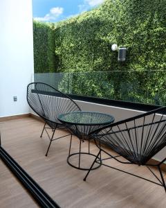 two chairs and a glass table in front of a window at Beachside Studio & Jacuzzi Bliss in Playa del Carmen